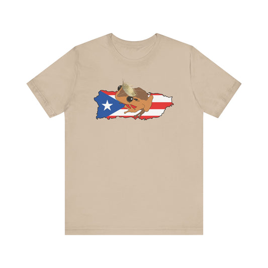 A beige crewneck t-shirt featuring a graphic of a cartoon dog wearing sunglasses and a hat, superimposed over a map of Puerto Rico filled with the Puerto Rican flag.