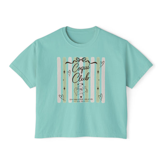 A mint green short-sleeve crop top t-shirt featuring a 'Coqui Club' graphic on the front with pastel stripes, hearts, and a cute cartoon character.